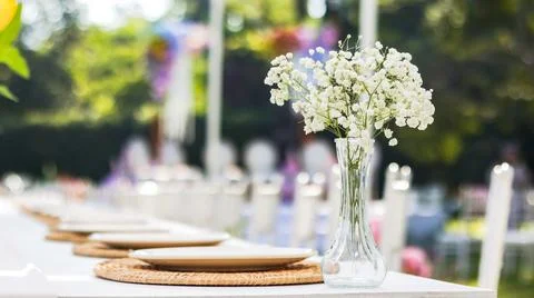 An elegantly set dining table at a wedding reception, featuring a pristine .. Stock Photos