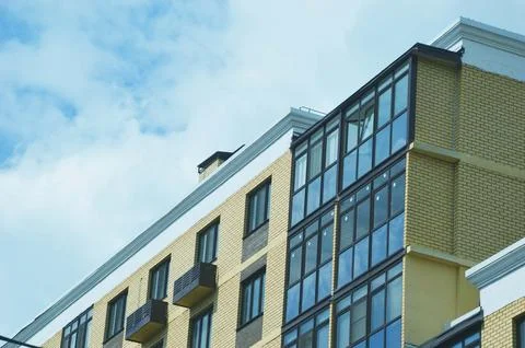 Element of a modern house with a brick facade, glass windows and loggias. M.. Stock Photos