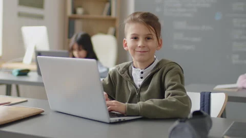 Elementary Age Boy Smiling at Camera in Classroom 스톡 동영상 244699367