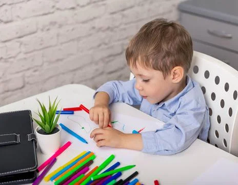 Elementary boy learning at home. Cute cheerful child drawing Foto stock