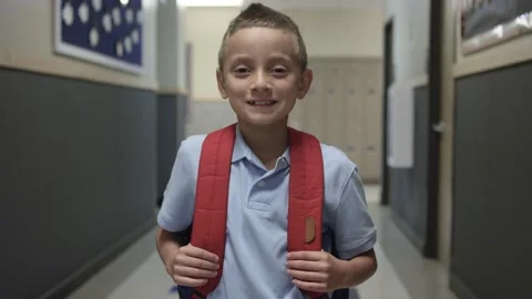 Elementary or Primary school boy with backpack smiles at camera in school hall Stock-Footage 140040086