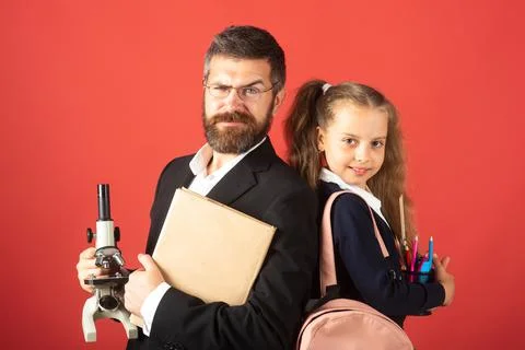 Elementary pupil with teacher in red studio, isolated. Portrait of funny school Stock Photos