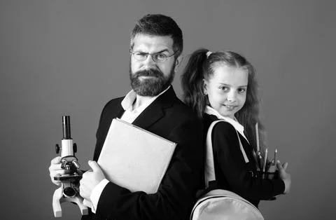 Elementary pupil with teacher in red studio, isolated. Portrait of funny school Stock Photos