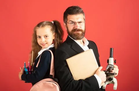 Elementary pupil with teacher in red studio, isolated. Portrait of funny school Stock Photos