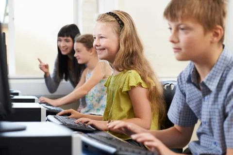 Elementary Pupils In Computer Class With Teacher Stock Photos