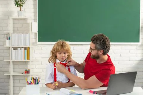 Elementary school boy in classroom on lesson. Teacher explaining to pupil 写真素材