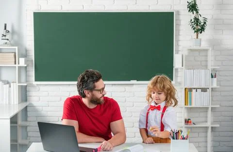 Elementary school boy in classroom on lesson. Teacher explaining to pupil 스톡 사진