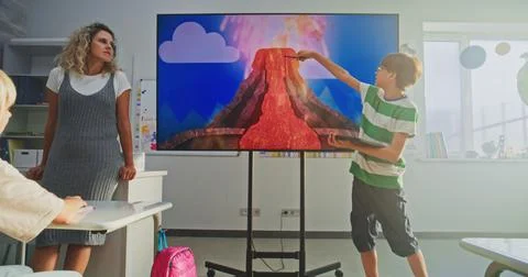 Elementary School Boy Presenting Homework, Explaining Volcanic Eruption Process Stock Photos