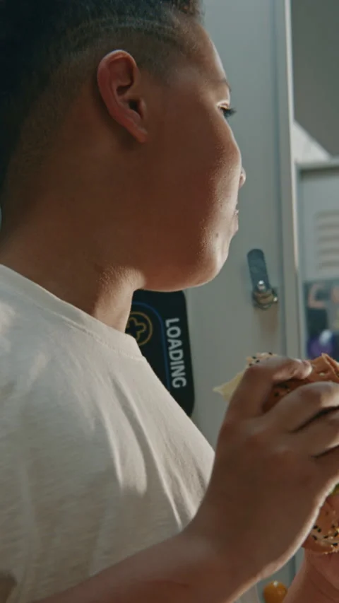 Elementary School Boy Takes Quick Bite of Packed Homemade Sandwich Stock Footage 342020562