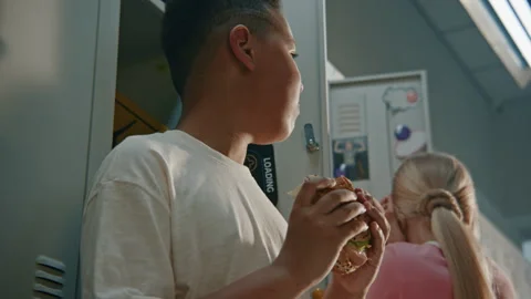 Elementary School Boy Takes Quick Bite of Packed Homemade Sandwich Stock Footage 342021495