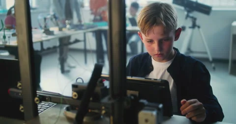 Elementary School Boy Writing Code for Advanced 3D Printer on Tablet Computer Stock Footage 311673860