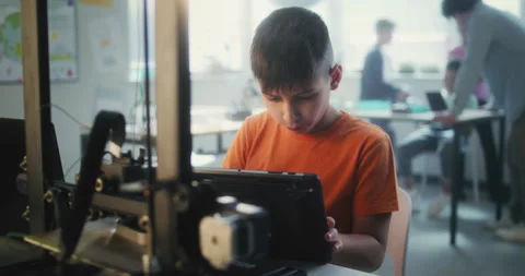 Elementary School Boy Writing Code for Advanced 3D Printer on Tablet Computer in Stock Footage 311674374
