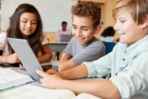 Elementary school boys using tablet computer in school class Stock Photos