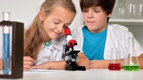 Elementary school chemistry class - kids looking through microscope Stock Footage 71884994