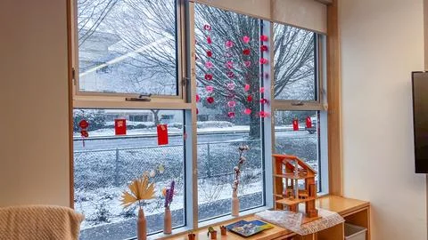 Elementary school classroom window decorated with red paper hearts and Luna.. Stock Photos