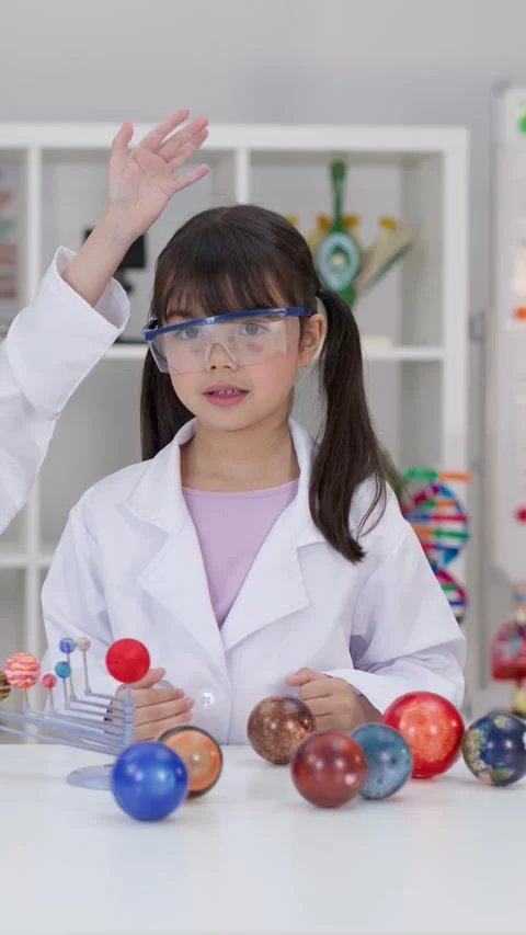 Elementary School Girl in Lab Coat Studying Solar System Model Stock Footage 341375717