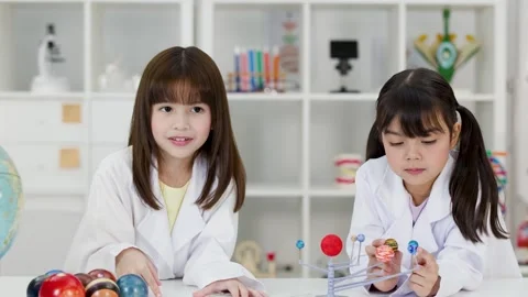 Elementary School Girls in Lab Coats Studying Solar System Model Stock Footage 341667671
