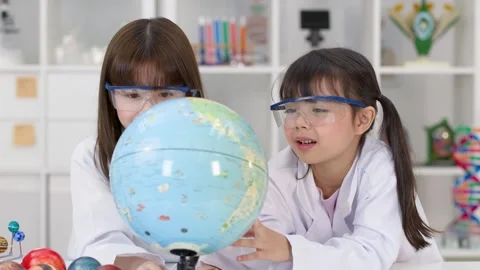 Elementary School Girls in Lab Coats Studying World Globe Stock Footage 341667709