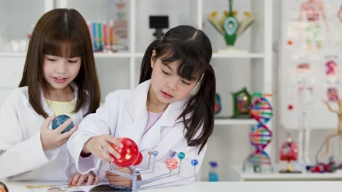 Elementary School Girls in Lab Coats Studying Solar System Model Stock Footage 341667728