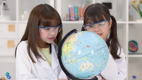 Elementary School Girls in Lab Coats Studying World Globe in Science Classroom Stock Footage 341667877