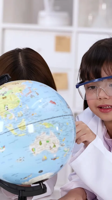 Elementary School Girls in Lab Coats Studying World Globe in Science Class Stock Footage 341835590
