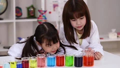 Elementary School Girls in Lab Coats Conducting Chemistry Experiment Stock Footage 341835653