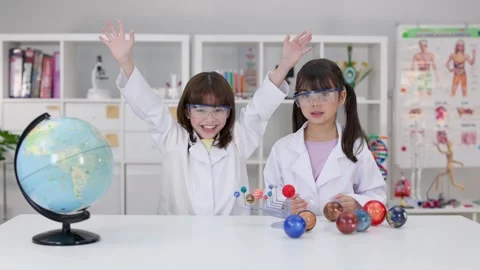 Elementary School Girls in Lab Coats Studying Solar System Model Stock Footage 341917229