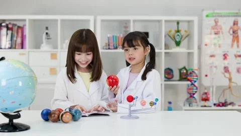 Elementary School Girls in Lab Coats Studying Solar System Model Stock Footage 342087349