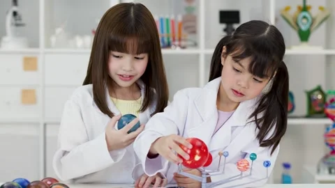 Elementary School Girls in Lab Coats Studying Solar System Model Stock Footage 342090391