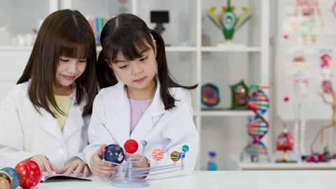 Elementary School Girls in Lab Coats Studying Solar System Model Stock Footage 342313074