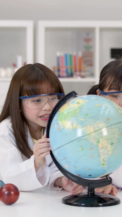 Elementary School Girls in Lab Coats Studying World Globe Stock Footage 342313102