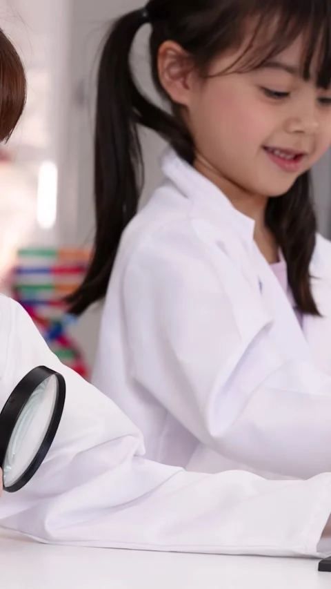 Elementary School Girls in Lab Coats Examining Science Models Stock Footage 345023125