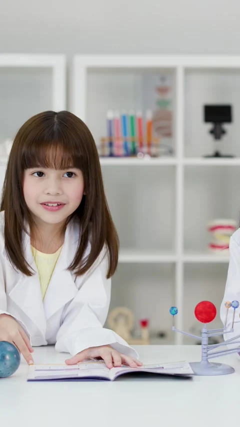 Elementary School Girls in Lab Coats Studying Solar System Model Stock Footage 345023154