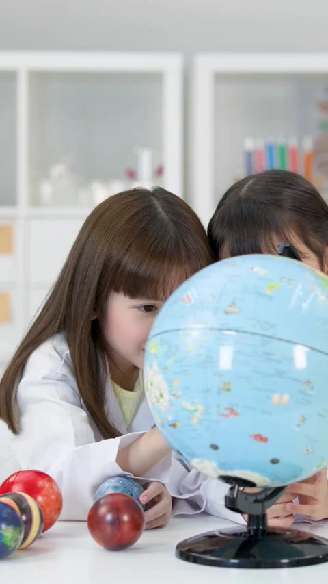 Elementary School Girls Studying World Globe in Science Classroom Stock Footage 341667706