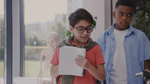 Elementary school kid listens teacher and joyfully writing in notebook in class Stock-Footage 162733792