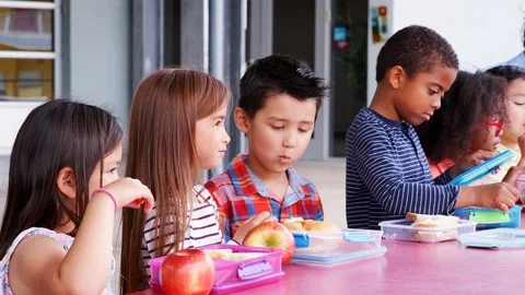 Elementary school kids eating at table w... | Stock Video | Pond5