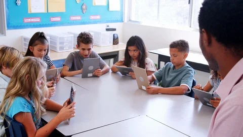 Elementary school kids using tablet computers in classroom Stock Footage