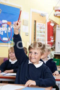 Elementary School Pupil Answering Question In Class Stock Photos
