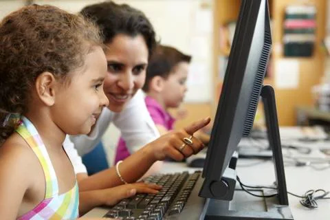 Elementary School Pupil With Teacher In Computer Class Stock Photos
