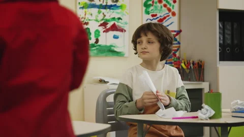 Elementary school pupils folding and throwing paper planes in classroom Stock Footage 335682290