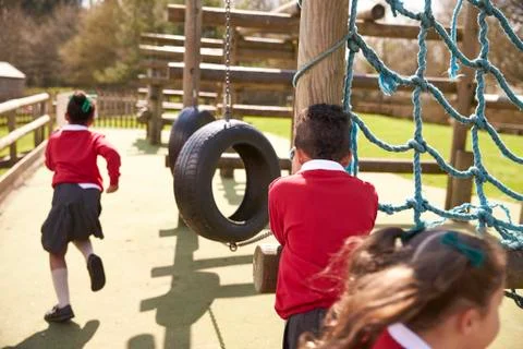 Elementary School Pupils Playing Hide And Seek At Breaktime Stock Photos