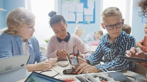 Elementary School Robotics Classroom: Diverse Group of Children Building Robot Stock Footage 119445782