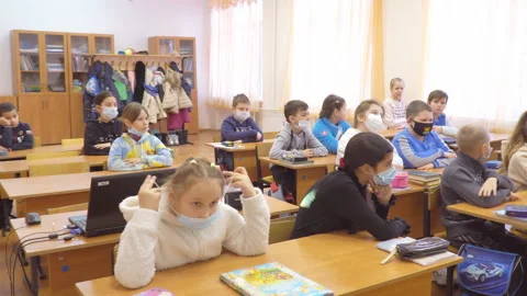 Elementary school Schoolchildren in the classroom in protective masks at their Stock Footage 170923688