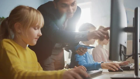 Elementary School Science Classroom Teacher Explains to Schoolgirl How to Use PC Stock Footage 119359576