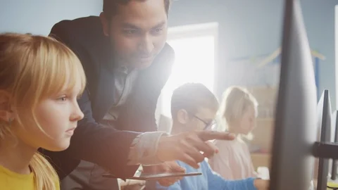 Elementary School Science Classroom Teacher Explains to Schoolgirl How to Use PC Stock Footage 119359661
