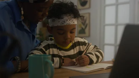 Elementary School Student and Mother Preparing Project Tasks at Table Stock Footage 280221846