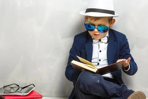 Elementary school student carrying notebooks over a gray background Stock Photos
