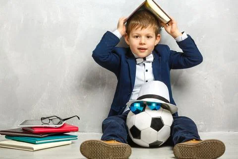 Elementary school student carrying notebooks over a gray background Stock Photos