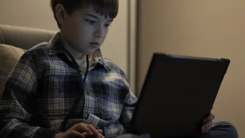 Elementary School Student Does Homework on Laptop While Sitting on Sofa in .. 스톡 동영상 300399416