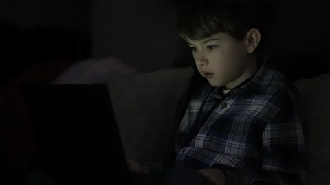 Elementary School Student Does Homework on Laptop While Sitting on Sofa in .. Stock-Footage 303379644